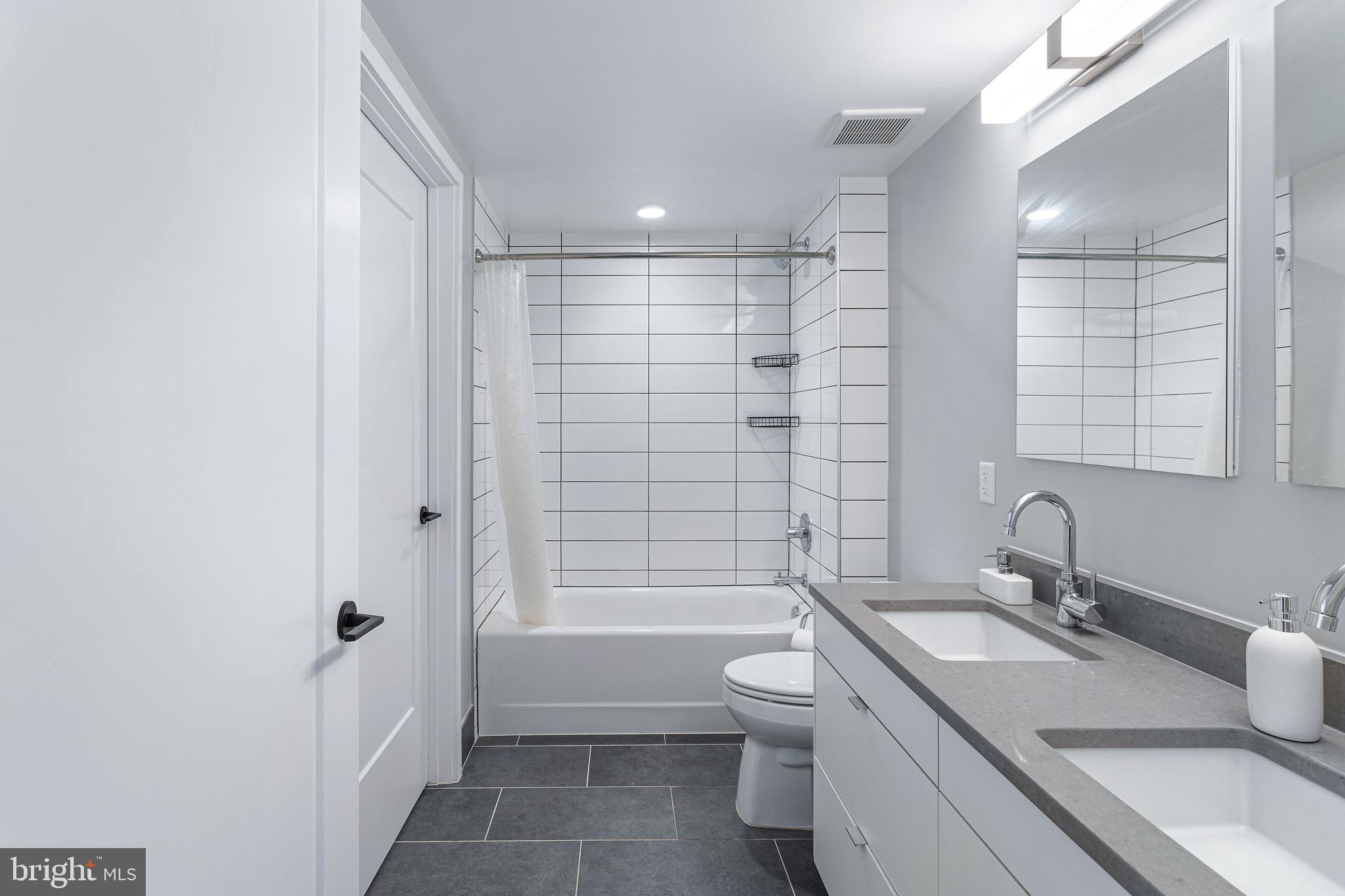 1300 4th Street Southeast, Unit 711 Washington, DC 20003 - Photo 15 of 28 a bathroom with a granite countertop sink a toilet and shower