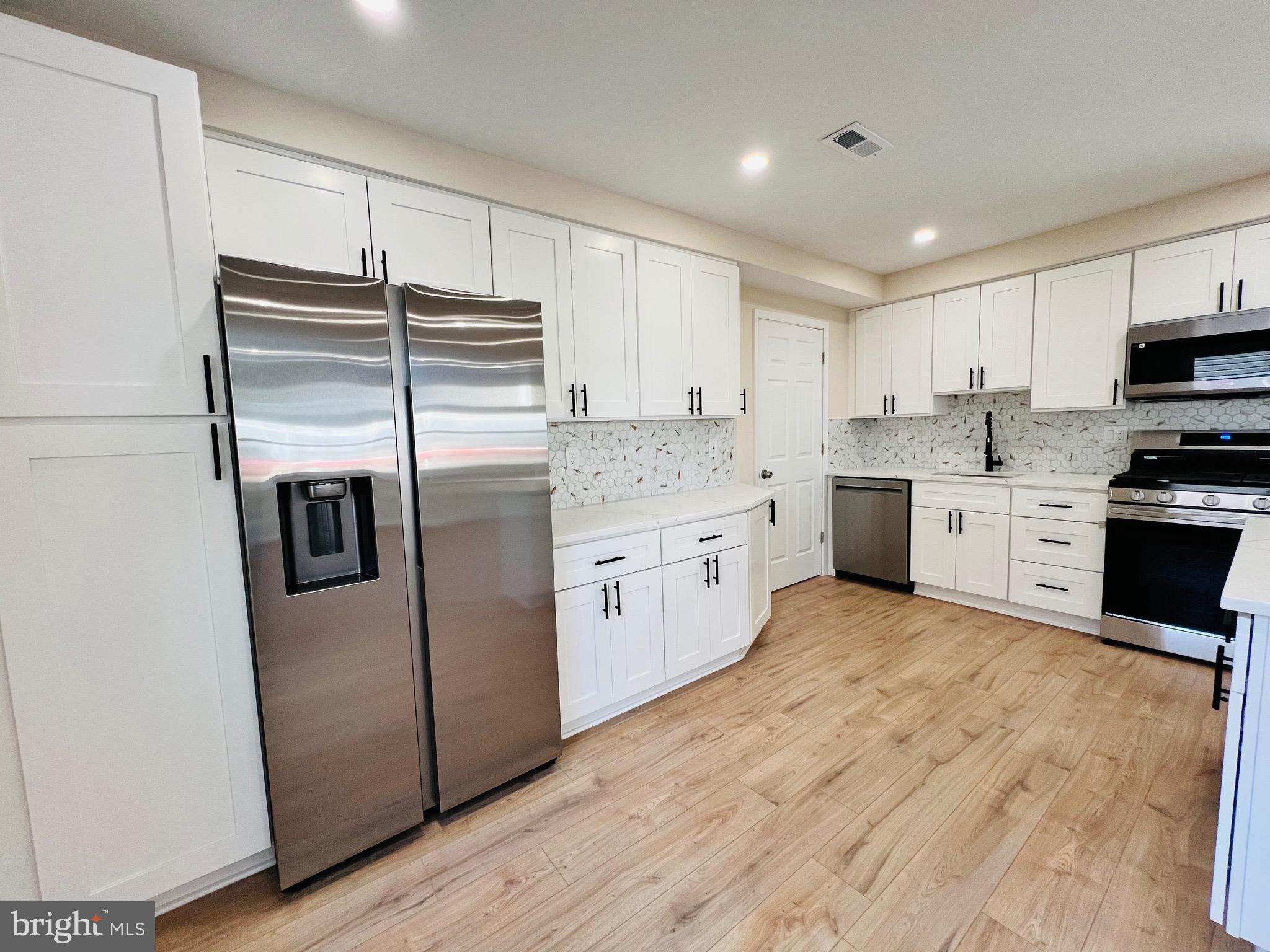 504 Selma Street Philadelphia, PA 19116 - Photo 12 of 31 a kitchen with stainless steel appliances granite countertop a refrigerator a stove a sink and white cabinets