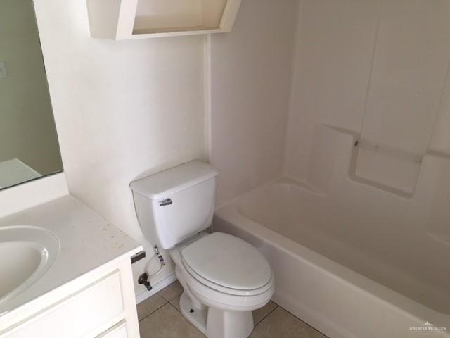 401 Rockport Street Alton, TX 78573 - Photo 8 of 11 Bathroom featuring light tile patterned flooring, vanity, and shower / tub combination