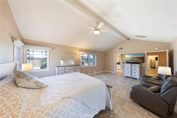 a spacious bedroom with a large bed and furniture