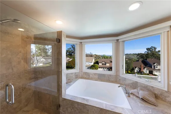 a bathroom with a tub a window and a shower