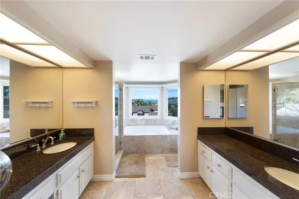 a spacious bathroom with a granite countertop sink mirror and bathtub