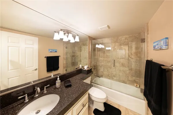 a bathroom with a sink a toilet a mirror and bathtub