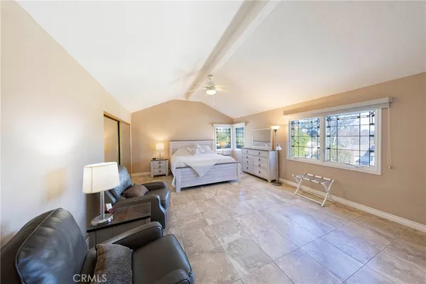 a bedroom with furniture and a large window