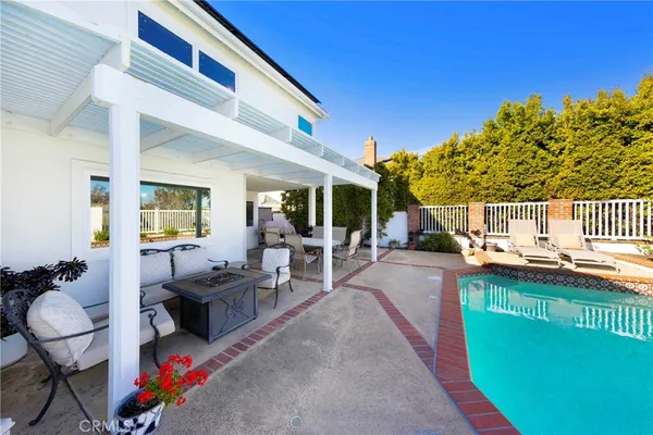 a view of a patio with couches table and chairs and potted plants