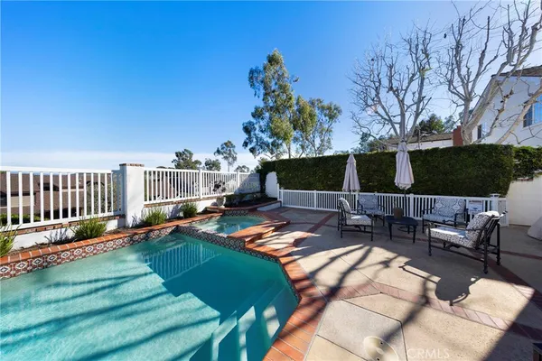 a view of a backyard with couches potted plants and wooden fence