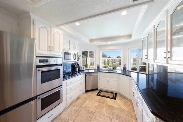 a kitchen with granite countertop a refrigerator stove top oven and sink