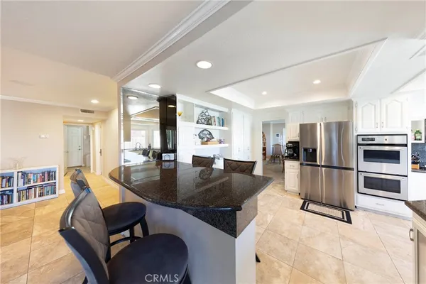 a kitchen with stainless steel appliances granite countertop a sink a stove and a refrigerator