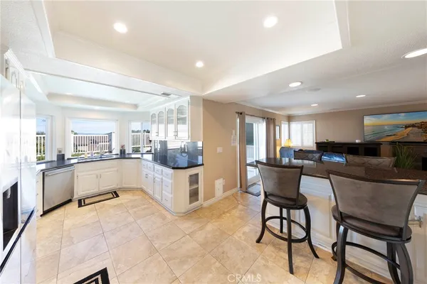a kitchen with a dining table chairs and refrigerator