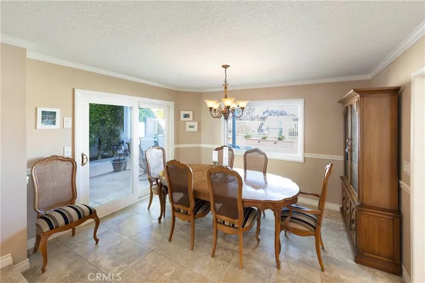 a dining room with furniture a chandelier and window