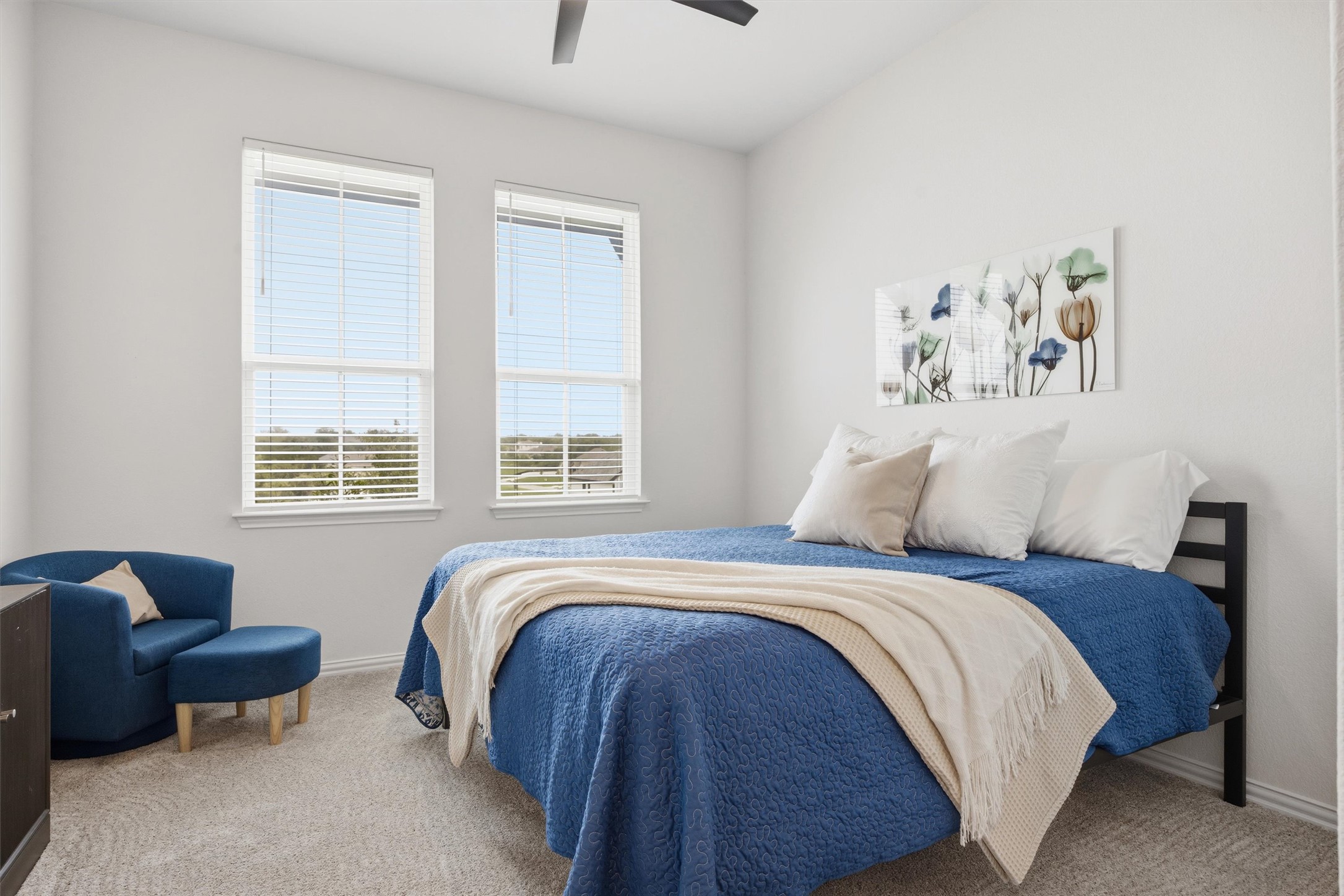 192 Raptor Beak Way Cedar Creek, TX 78612 - Photo 22 of 38 Carpeted bedroom featuring two large windows, white walls, and a ceiling fan