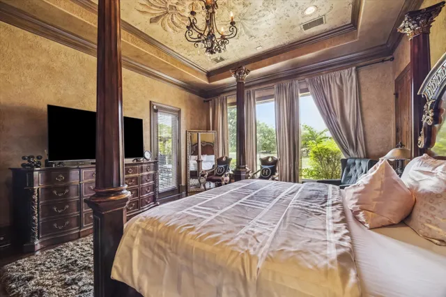 a bedroom with a bed and large windows