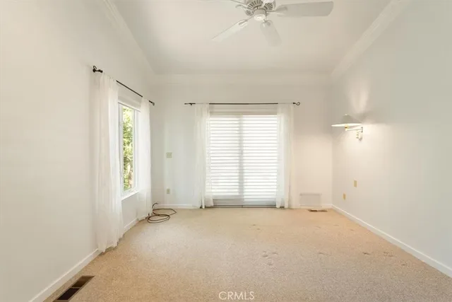 an empty room with windows and fan