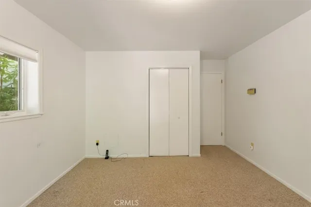 an empty room with windows and closet