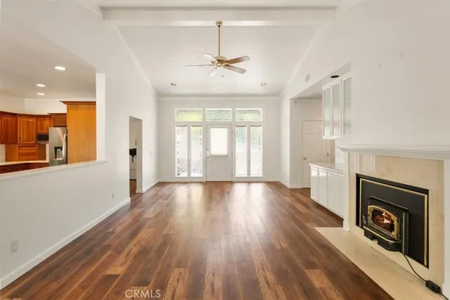 a view of an empty room with window and wooden floor