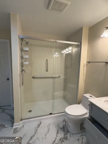 a bathroom with a toilet and a shower