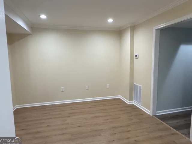 an empty room with wooden floor and entrance