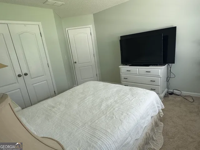 a bedroom with a bed and a flat screen tv