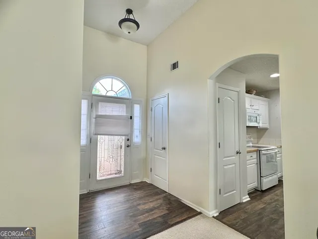 wooden floor in an empty room with a kitchen