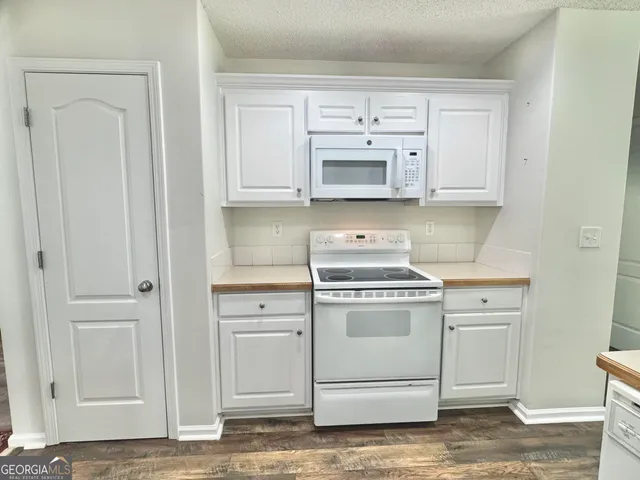 a kitchen with white cabinets and white appliances