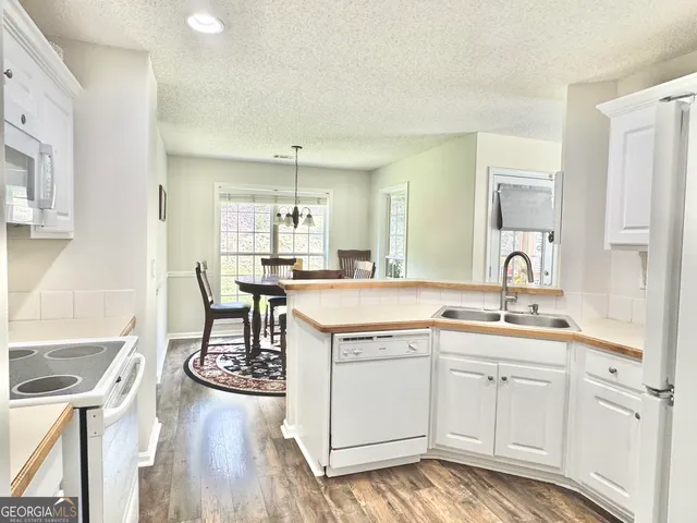 a kitchen with a sink cabinets and wooden floor