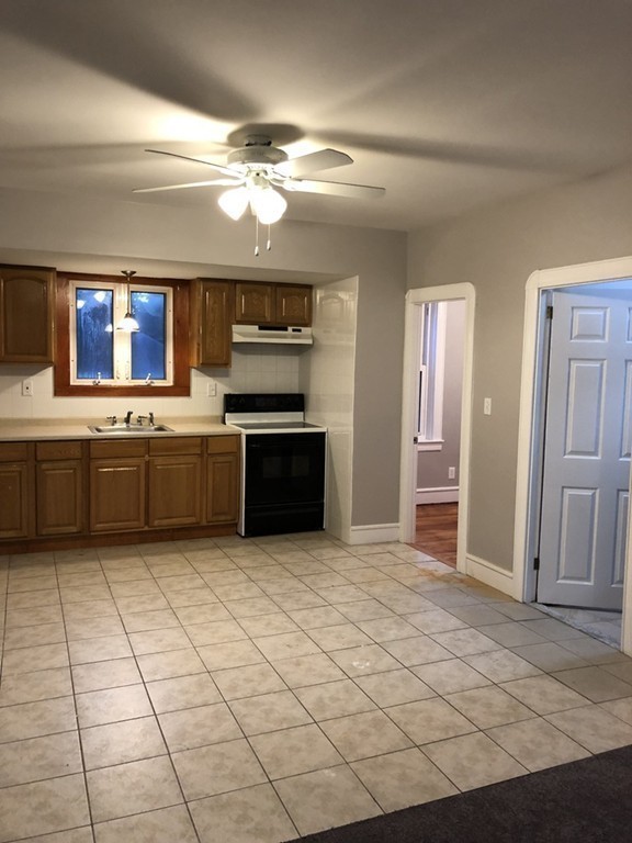 227 Ames Street Fall River, MA 02721 - Photo 12 of 18 a large kitchen with cabinets and stainless steel appliances