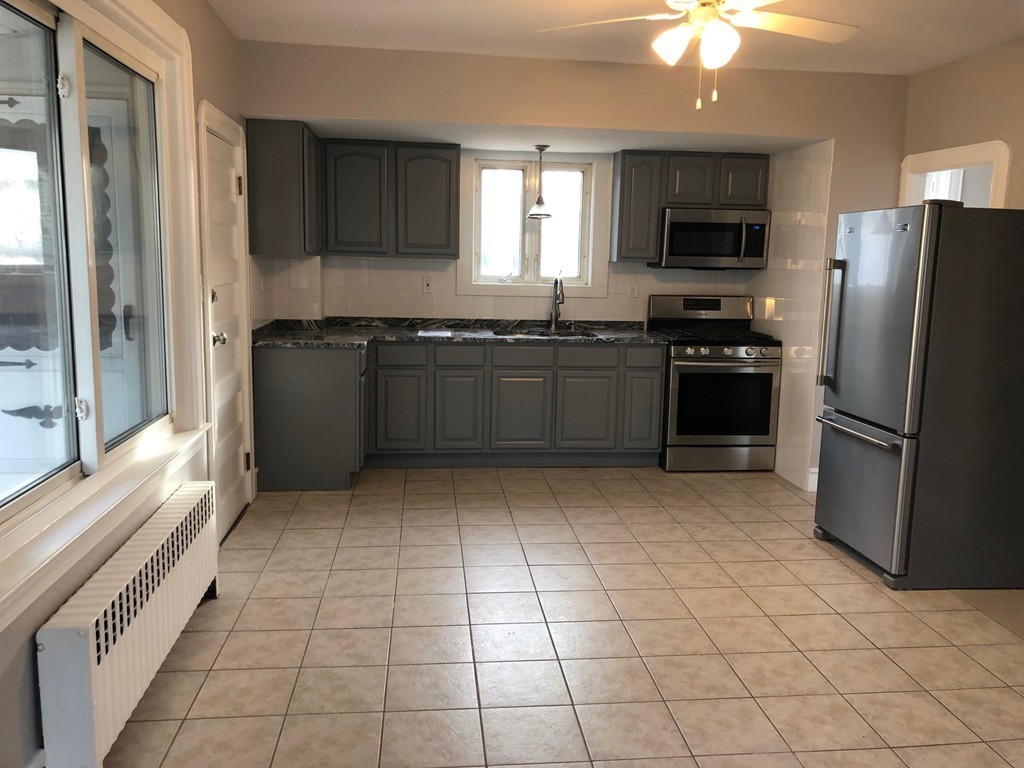 227 Ames Street Fall River, MA 02721 - Photo 4 of 18 a kitchen with stainless steel appliances granite countertop a refrigerator and a stove top oven