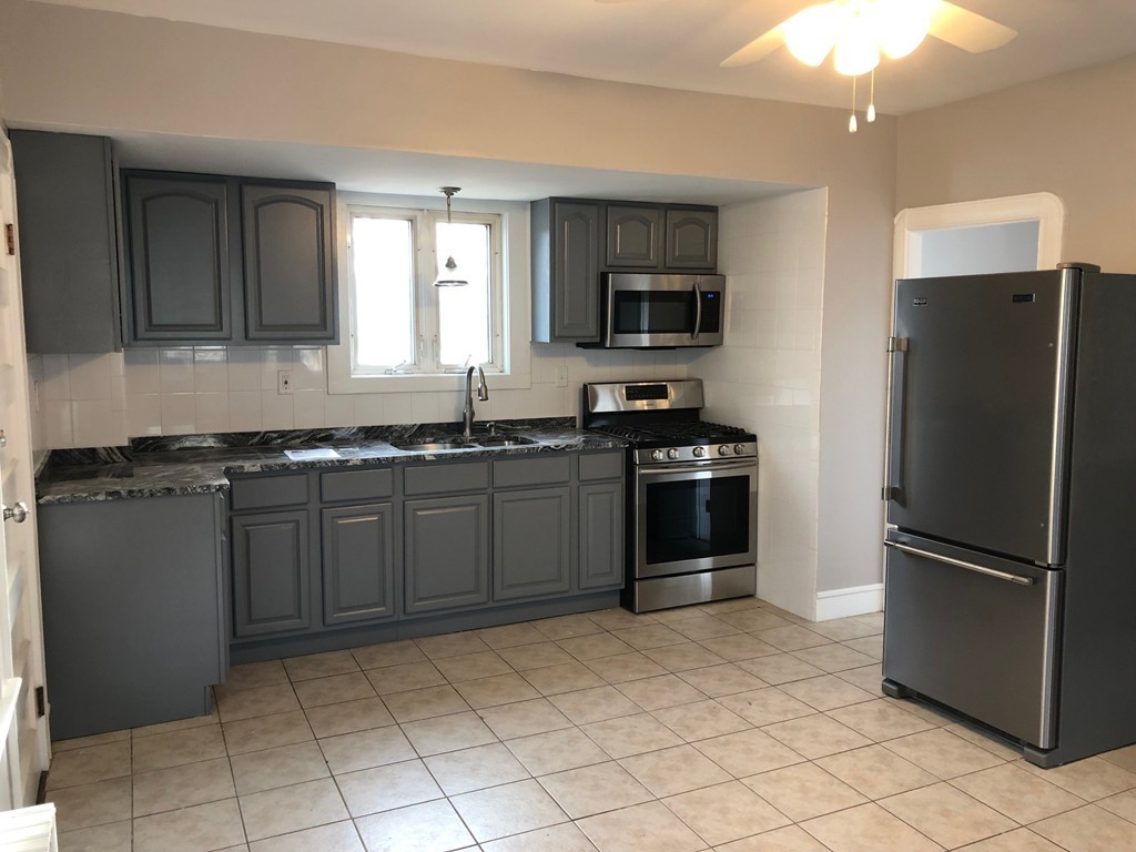 227 Ames Street Fall River, MA 02721 - Photo 5 of 18 a kitchen with a sink a stove and refrigerator