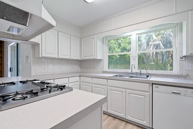 a kitchen with white cabinets and white appliances