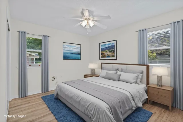 a view of a room with wooden floor and a ceiling fan