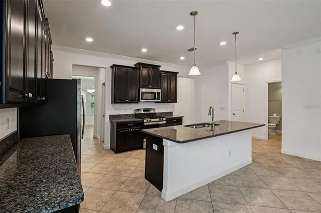 a kitchen with stainless steel appliances granite countertop a sink stove and refrigerator