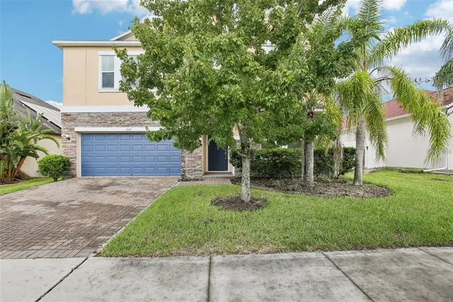 a front view of a house with a yard and palm trees