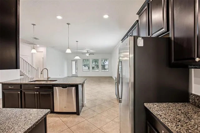 a kitchen with stainless steel appliances granite countertop a sink a stove and a refrigerator