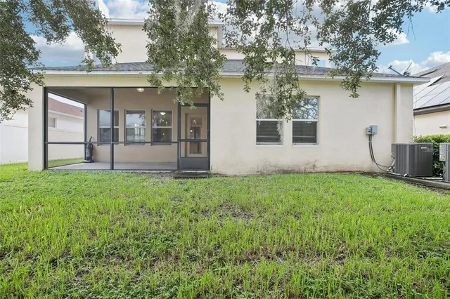 a view of a house with backyard and a tree