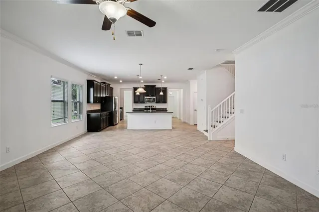 a view of a electric appliances in kitchen and empty room with wooden floor