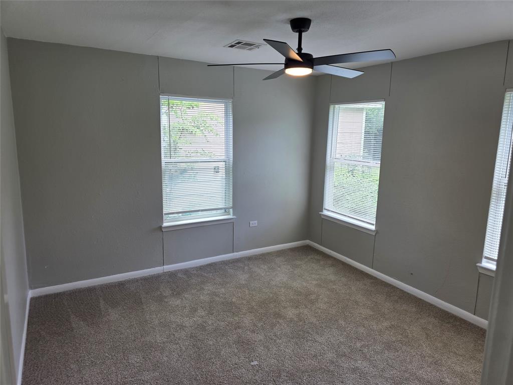 2804 Summer Avenue Waco, TX 76708 - Photo 6 of 13 Carpeted room featuring multiple windows with blinds, a ceiling fan with integrated lighting, and neutral wall tones