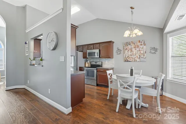 a view of a dining room with furniture a chandelier and wooden floor