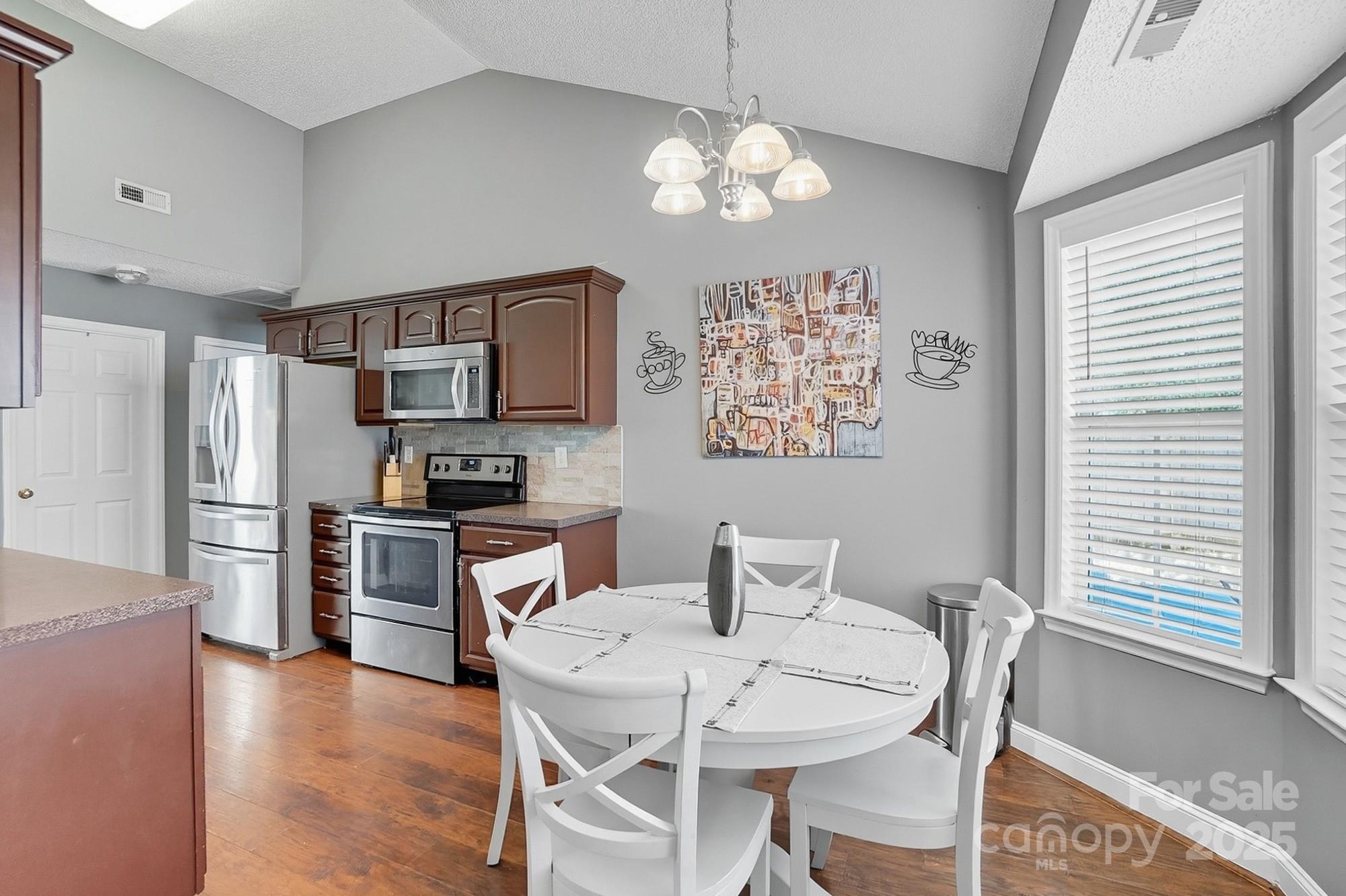 12639 Hill Pine Road Midland, NC 28107 - Photo 12 of 45 a kitchen with stainless steel appliances granite countertop a dining table and chairs