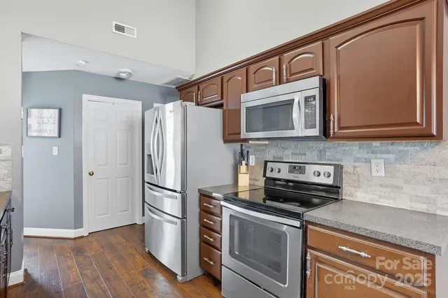 a kitchen with stainless steel appliances granite countertop a refrigerator and a microwave