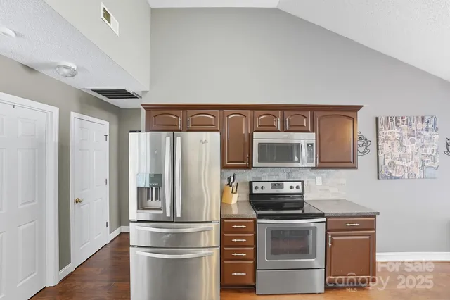a kitchen with stainless steel appliances granite countertop a stove and a refrigerator