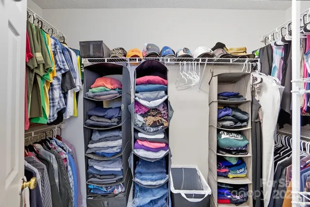 a view of walk in closet with clothes and shoes