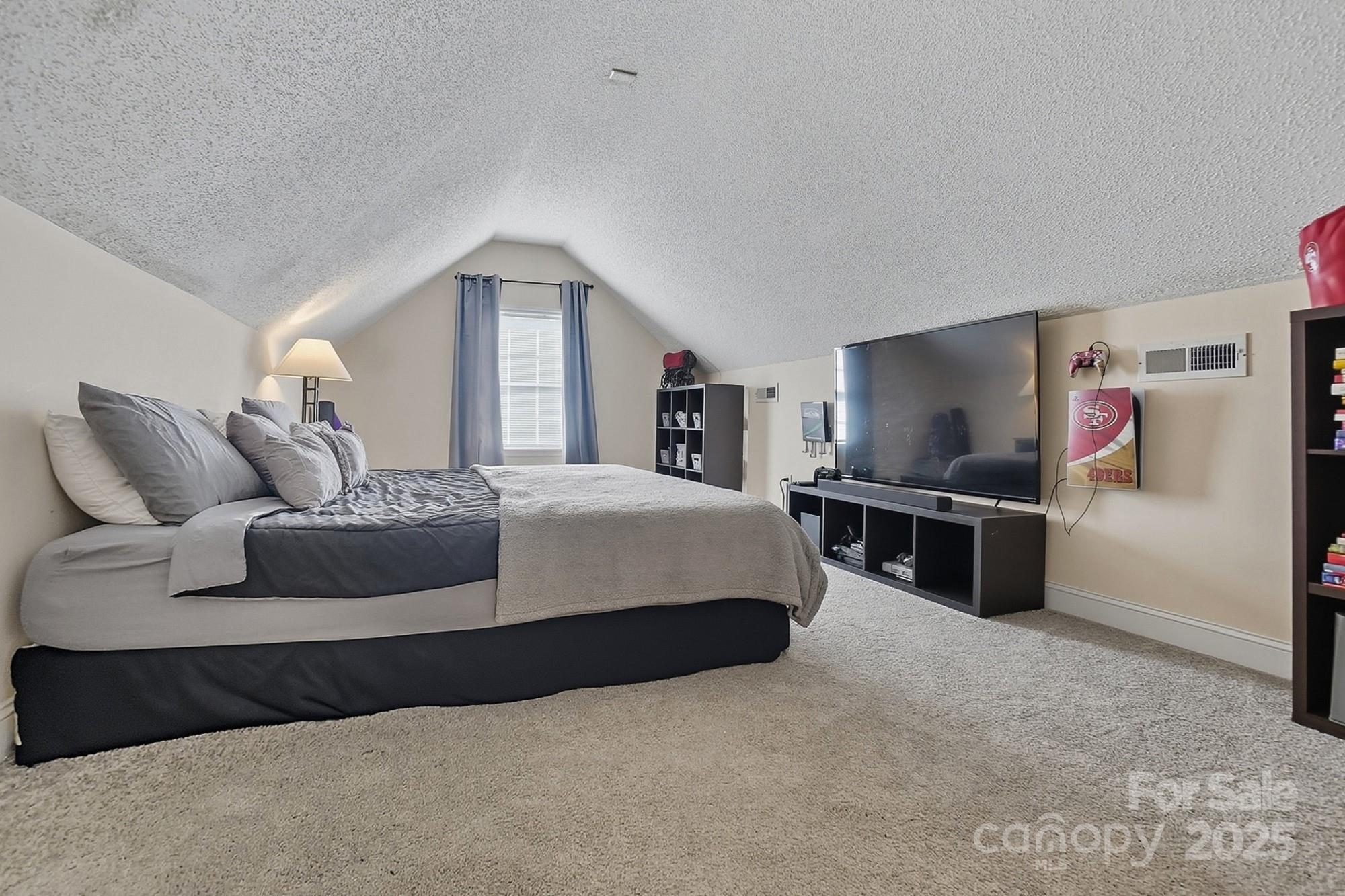 12639 Hill Pine Road Midland, NC 28107 - Photo 35 of 45 a spacious bedroom with a bed and a flat screen tv