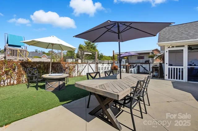 a view of a roof deck with table and chairs under an umbrella