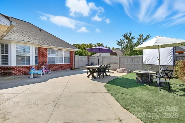 a view of a backyard with table and chairs under an umbrella