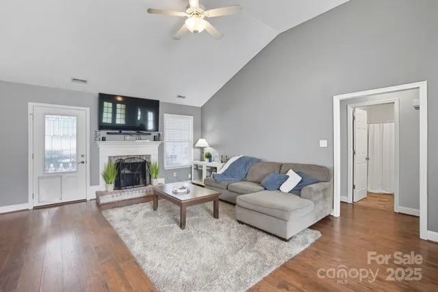 a living room with furniture a fireplace and a flat screen tv