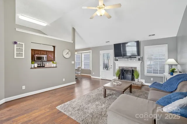 a living room with furniture a fireplace and a flat screen tv