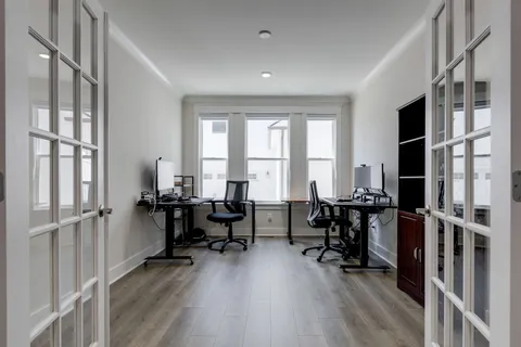 a view of a workspace with furniture and a window