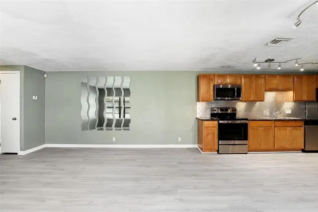 a view of kitchen with kitchen island granite countertop a stove top oven a sink and dishwasher