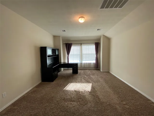 an empty room with windows and fireplace