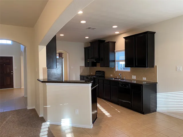 a kitchen with stainless steel appliances granite countertop refrigerator and a stove top oven